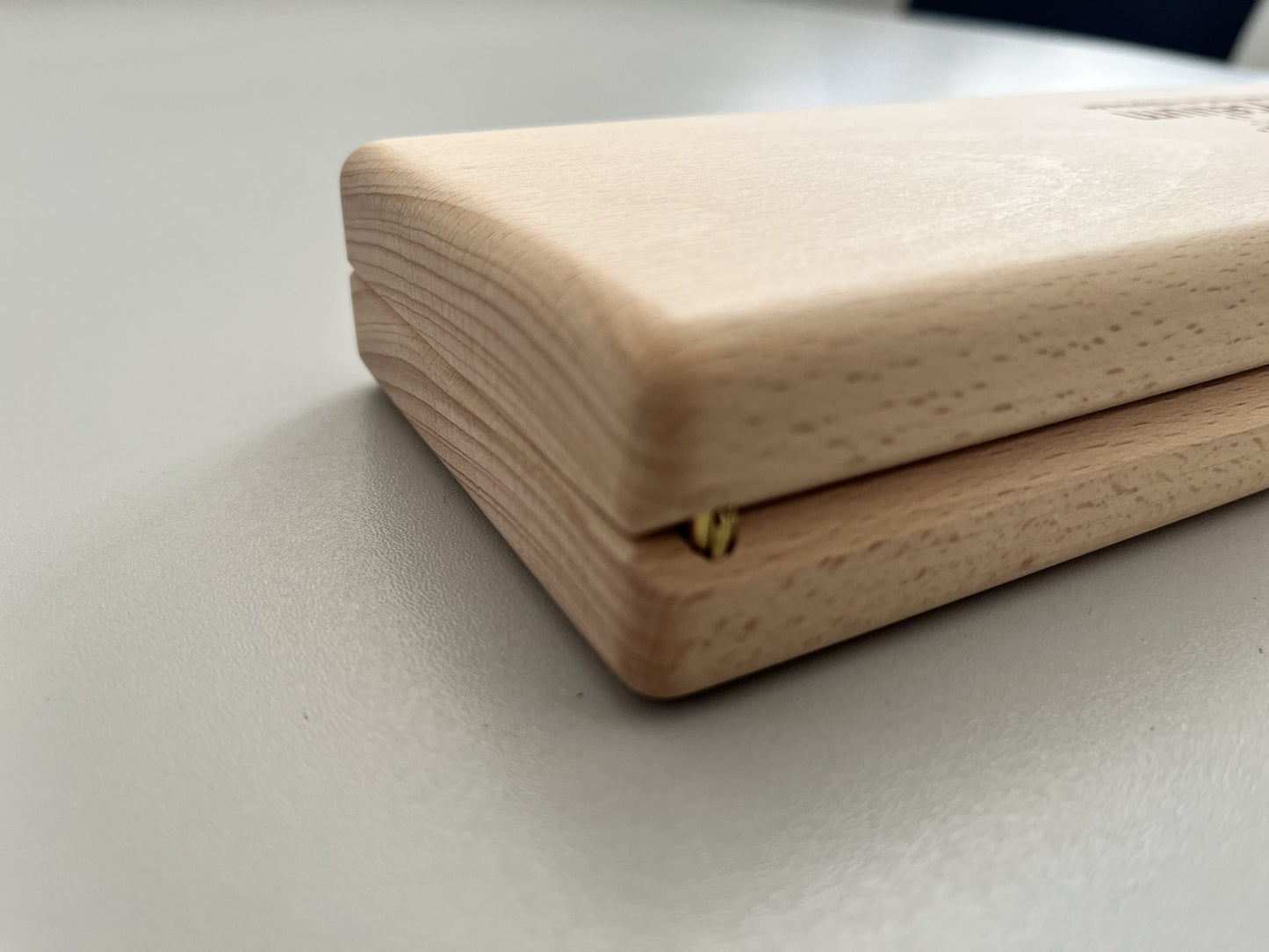 Detailaufnahme der Scharniere einer hochwertigen Pillendose aus Holz.