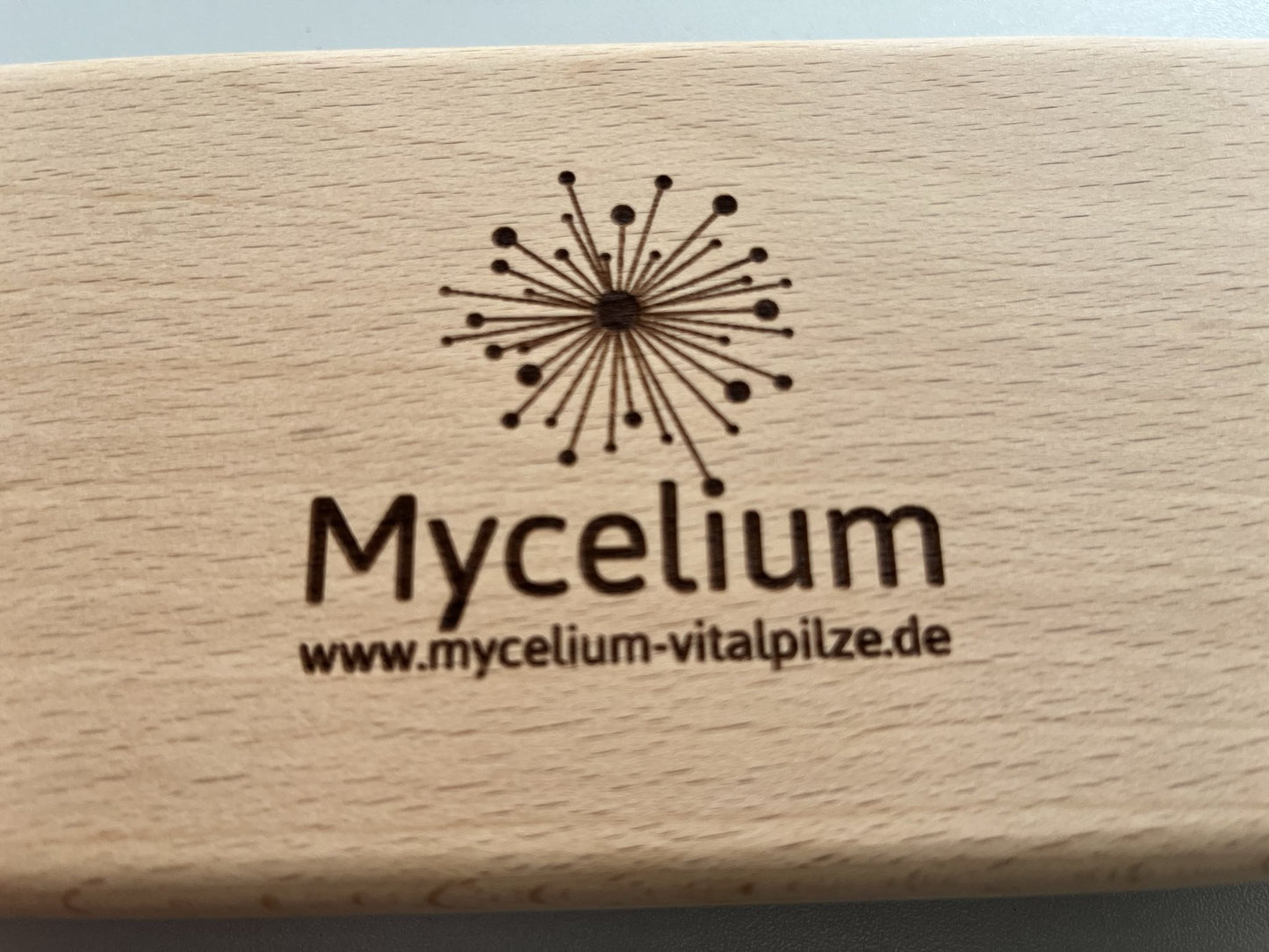 Graviertes Mycelium-Logo auf der Holz-Pillendose.