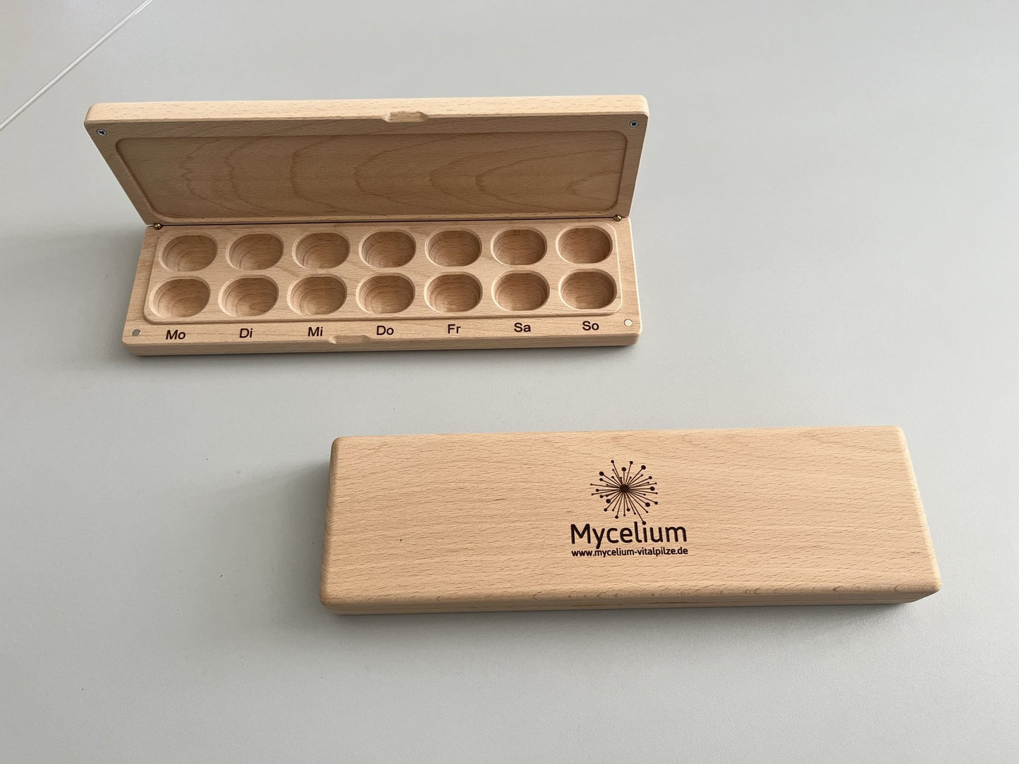 Praktische Holzdose mit 14 Fächern für eine ganze Woche – ideal zur Aufbewahrung von Vitalpilz-Kapseln.