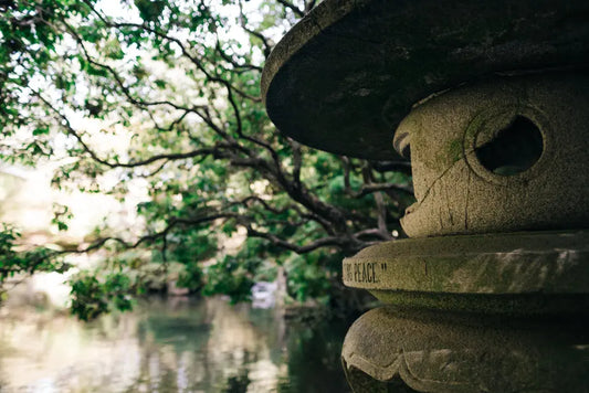 Steinlaterne in einem Zen-Garten, ein Symbol für Harmonie und Ruhe, ähnlich der sorgfältigen Kultivierung von Vitalpilzen, die höchste Qualitätsstandards und Reinheit in der traditionellen Gesundheitspflege repräsentiert.