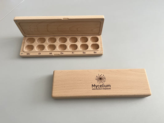 Praktische Holzdose mit 14 Fächern für eine ganze Woche – ideal zur Aufbewahrung von Vitalpilz-Kapseln.